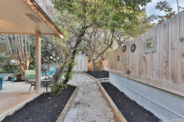 view of yard with a storage unit and a patio area