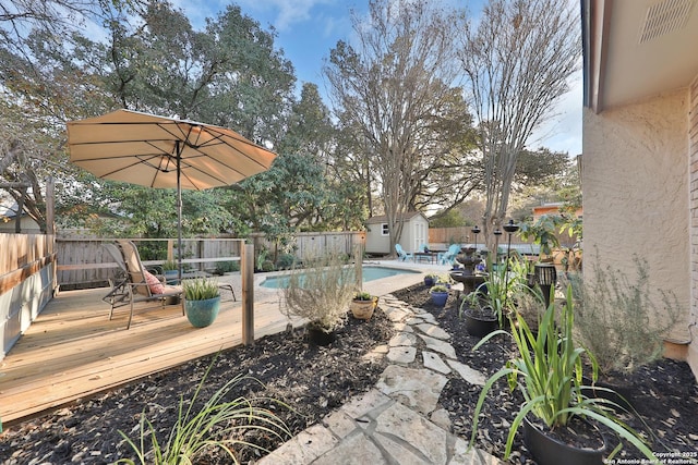 view of yard featuring a pool side deck and a storage unit