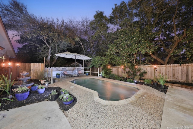 pool at dusk featuring a patio