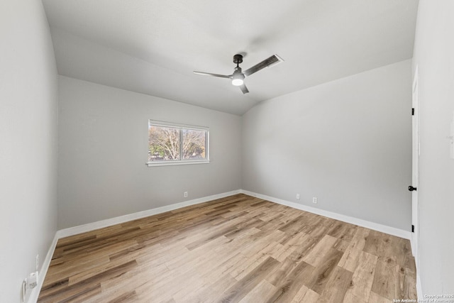 empty room with lofted ceiling, ceiling fan, and light hardwood / wood-style flooring