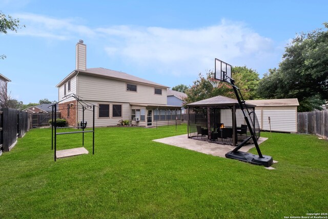 rear view of house featuring a gazebo, a yard, a storage unit, and a patio