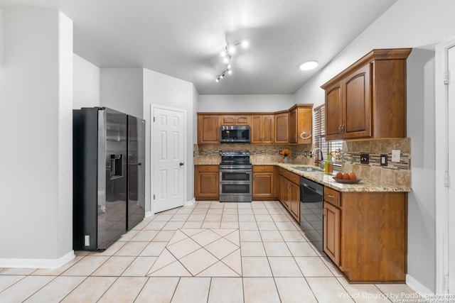 kitchen featuring stainless steel appliances, light stone countertops, backsplash, and sink