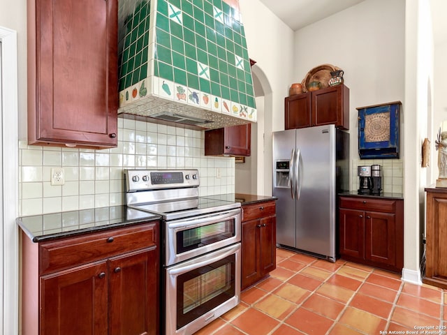 kitchen featuring custom exhaust hood, light tile patterned floors, backsplash, and appliances with stainless steel finishes