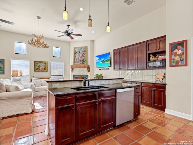 kitchen featuring sink, stainless steel dishwasher, backsplash, a kitchen island with sink, and light tile patterned floors