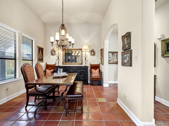 tiled dining room with an inviting chandelier