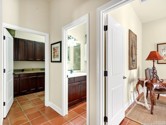 hallway with light tile patterned flooring and sink