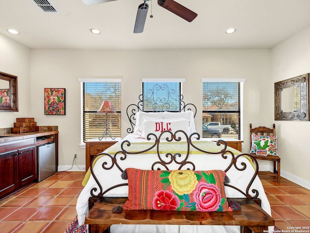 bedroom with light tile patterned floors, refrigerator, and ceiling fan