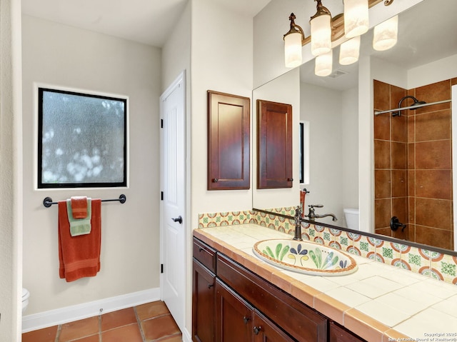 bathroom with tile patterned floors, vanity, toilet, and a tile shower