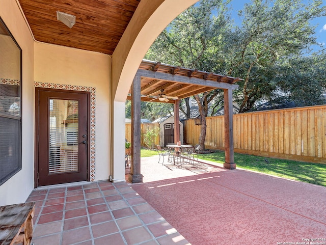 view of patio with ceiling fan and a storage unit