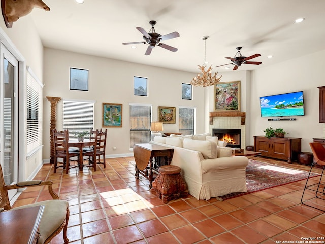 living room with ceiling fan with notable chandelier and tile patterned floors