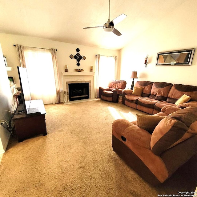 carpeted living room with ceiling fan and a fireplace