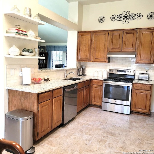 kitchen with decorative backsplash, sink, light stone counters, and stainless steel appliances