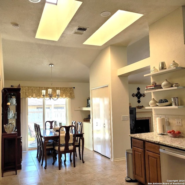 dining space with a notable chandelier and vaulted ceiling with skylight