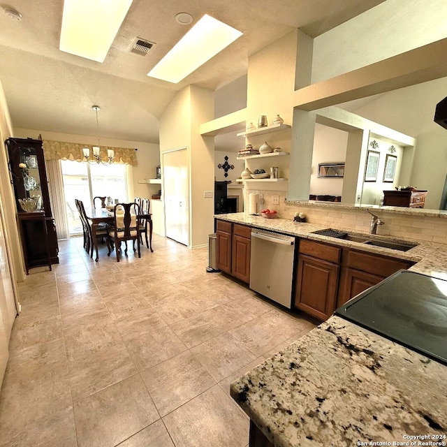 kitchen featuring sink, stainless steel dishwasher, a chandelier, decorative light fixtures, and vaulted ceiling with skylight