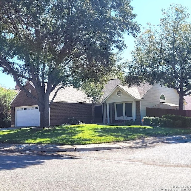 ranch-style house with a garage and a front lawn