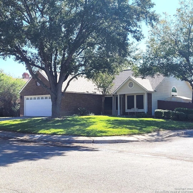 ranch-style home featuring a front lawn and a garage