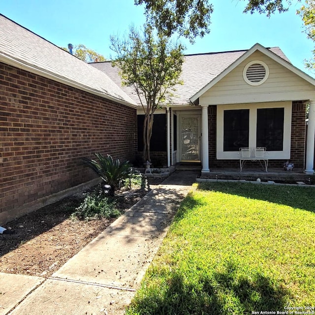 view of exterior entry featuring a yard