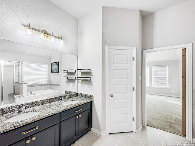 bathroom featuring tile patterned flooring, vanity, and shower with separate bathtub