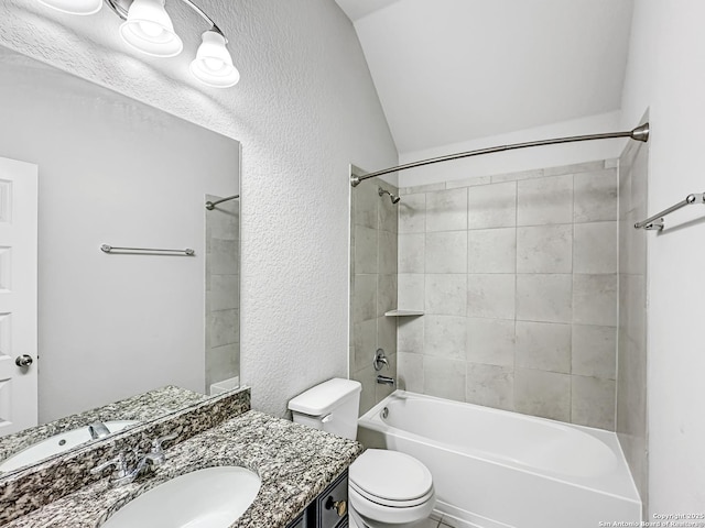 full bathroom featuring tiled shower / bath combo, toilet, vanity, and vaulted ceiling