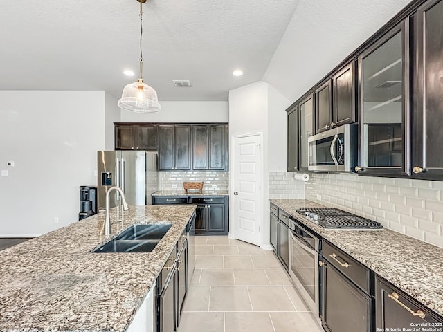 kitchen featuring backsplash, sink, hanging light fixtures, dark brown cabinets, and stainless steel appliances