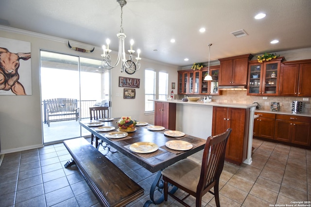 tiled dining area featuring crown molding and a chandelier