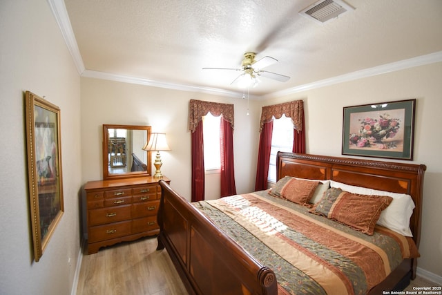 bedroom featuring ceiling fan, crown molding, light hardwood / wood-style floors, and a textured ceiling