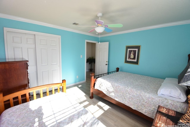 bedroom with a closet, ceiling fan, crown molding, and hardwood / wood-style flooring