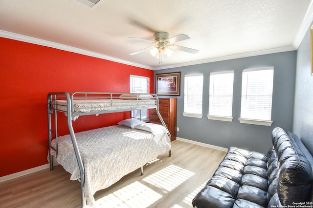 bedroom with ceiling fan, light hardwood / wood-style flooring, a textured ceiling, and ornamental molding