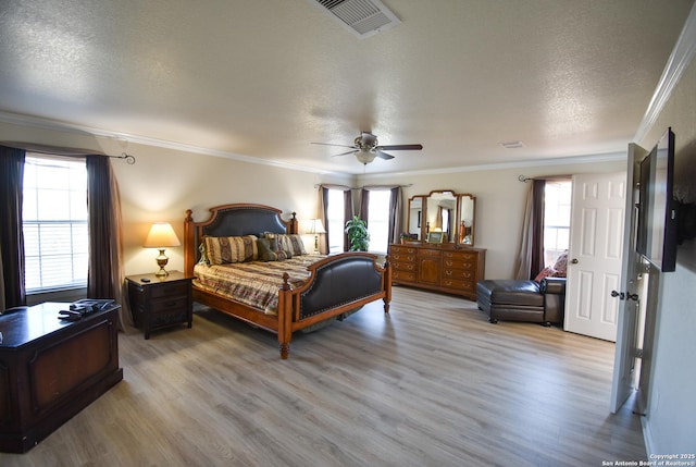 bedroom featuring a textured ceiling, ceiling fan, light wood-type flooring, and crown molding