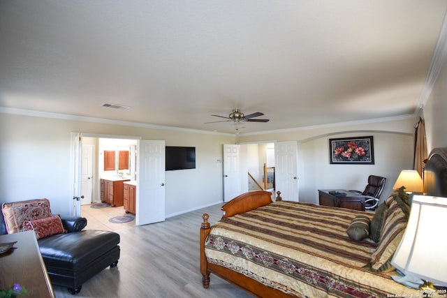 bedroom with ensuite bathroom, light hardwood / wood-style flooring, ceiling fan, and crown molding