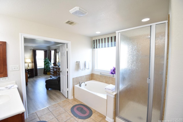 bathroom featuring tile patterned floors, vanity, and shower with separate bathtub