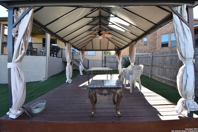 wooden terrace featuring a gazebo and ceiling fan