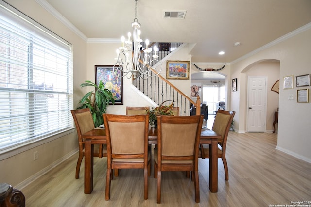 dining room with plenty of natural light, crown molding, and a notable chandelier