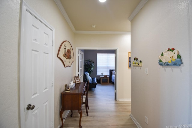 hallway with crown molding and light hardwood / wood-style flooring