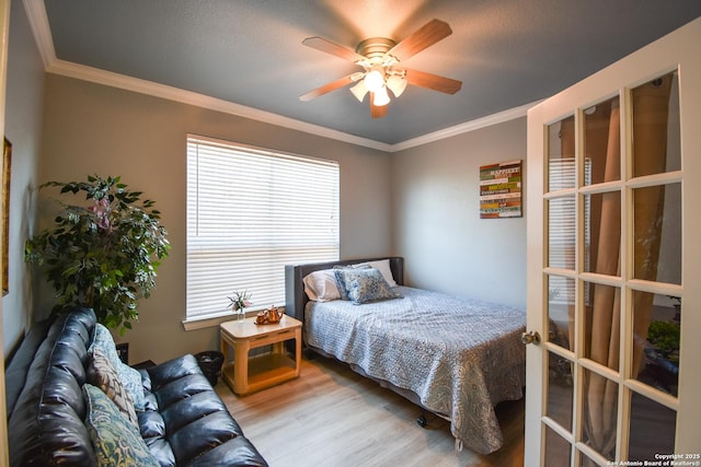 bedroom with light hardwood / wood-style flooring, ceiling fan, and crown molding