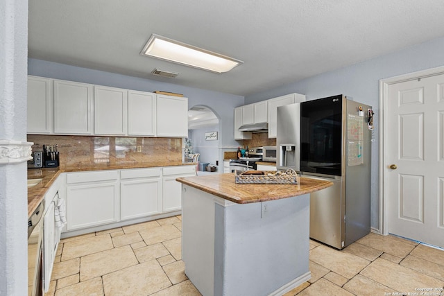 kitchen with a center island, white cabinetry, appliances with stainless steel finishes, and tasteful backsplash