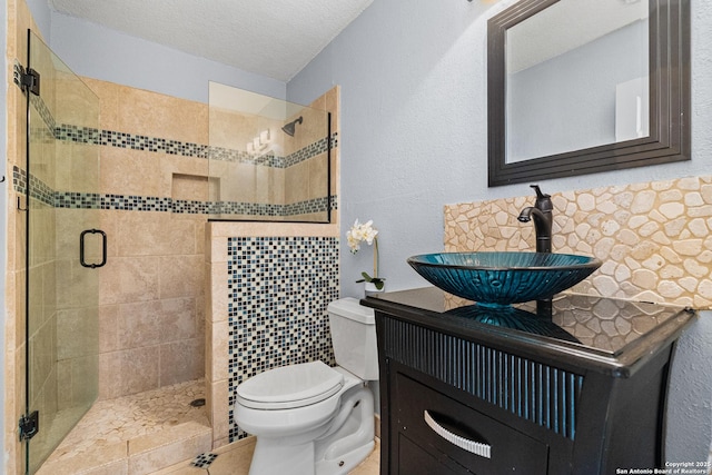 bathroom featuring vanity, toilet, an enclosed shower, and a textured ceiling