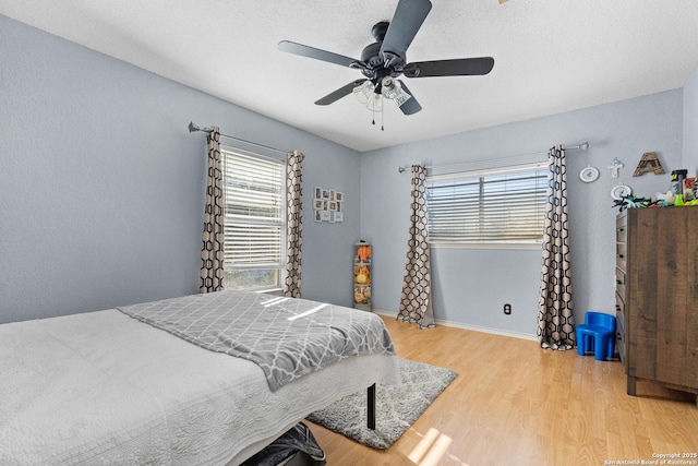 bedroom with ceiling fan and light hardwood / wood-style floors