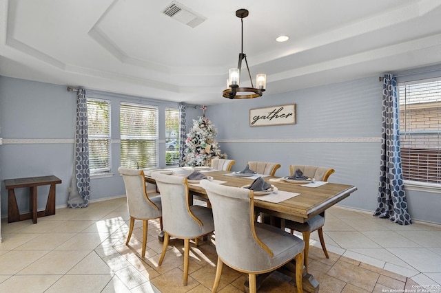 dining room featuring a raised ceiling, light tile patterned floors, and a chandelier