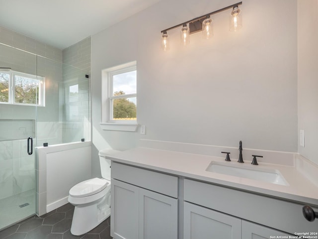 bathroom with tile patterned floors, toilet, vanity, and walk in shower