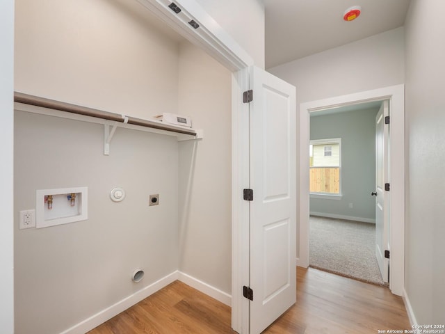 washroom with hookup for an electric dryer, washer hookup, light hardwood / wood-style floors, and hookup for a gas dryer