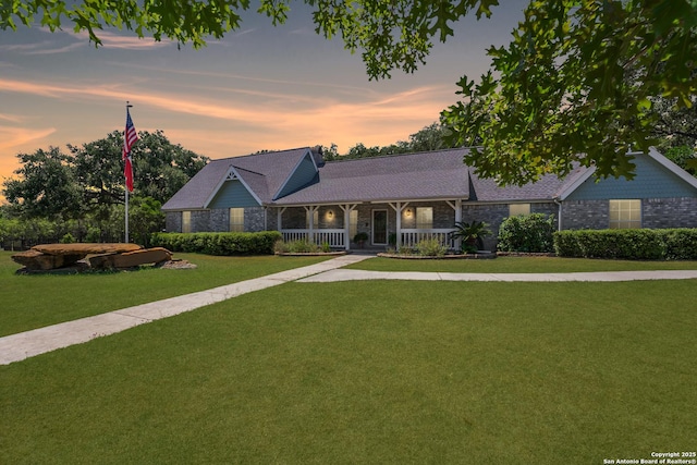 view of front of property with a porch and a yard