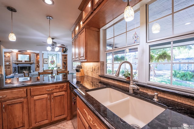 kitchen featuring decorative light fixtures, plenty of natural light, sink, and dark stone counters