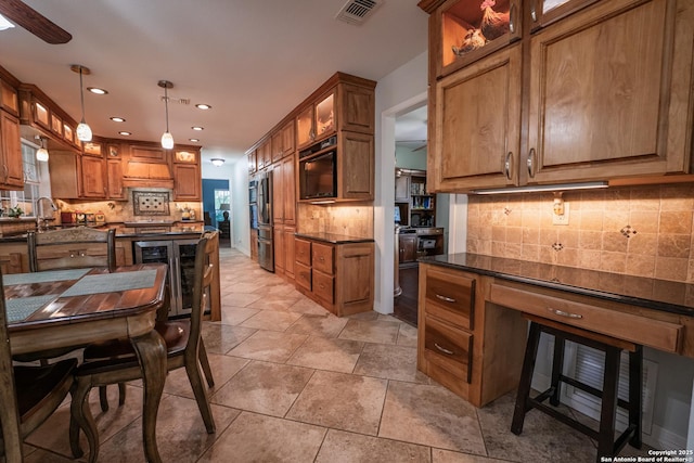 kitchen featuring pendant lighting, premium range hood, beverage cooler, and dark stone counters