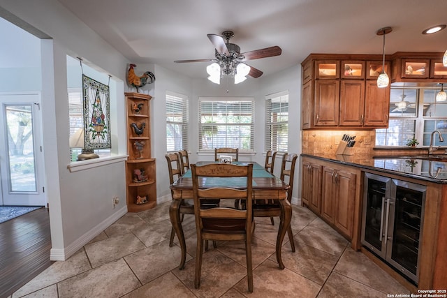 dining space featuring wine cooler, ceiling fan, and light tile patterned flooring