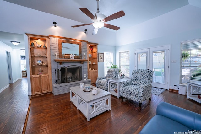 living room featuring dark wood-type flooring, french doors, a brick fireplace, vaulted ceiling, and ceiling fan