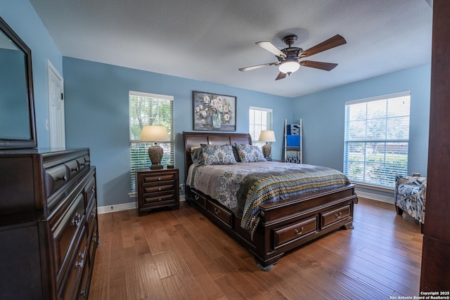 bedroom featuring ceiling fan, dark hardwood / wood-style flooring, and a textured ceiling