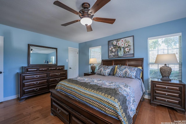 bedroom with ceiling fan and dark wood-type flooring