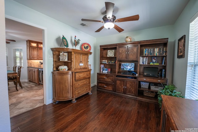 home office with ceiling fan and dark wood-type flooring