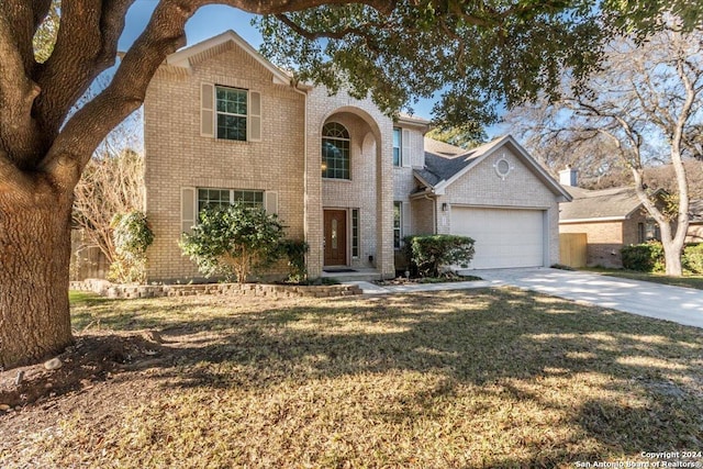 view of property featuring a garage and a front lawn